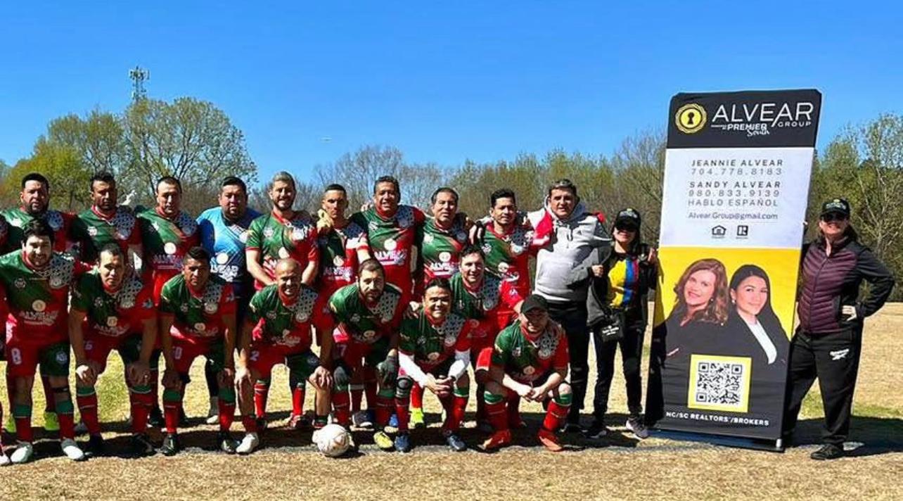 Soccer team with Alvear Group banner sponsored by Sandy and Jeannie
